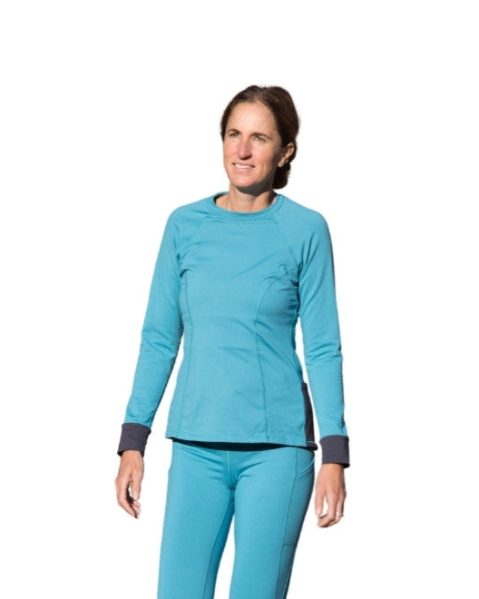 Tall woman wearing a Alta Reina tall women's baselayers on a white background